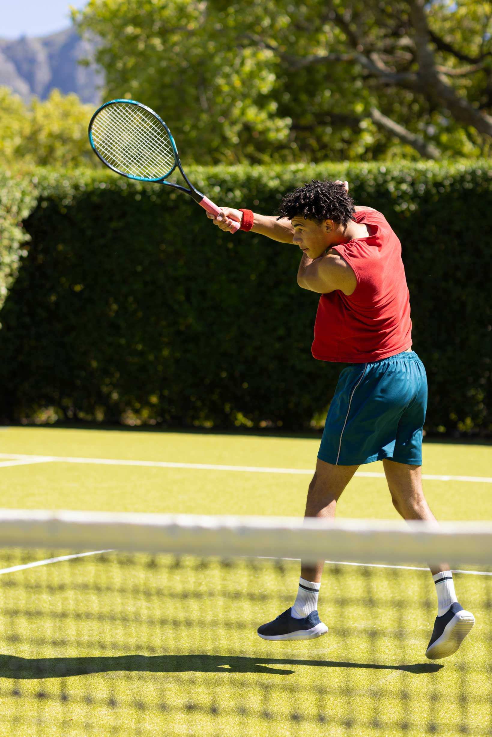 biracial-man-returning-ball-with-racket-on-sunny